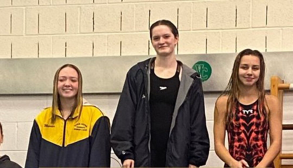 Newburgh’s Elle Gerbes (c.) stands on the podium after winning the 50-yard freestyle at the Section 9 girls’ swimming championships on Nov. 4 at Valley Central High School. She will compete in the 50- and 100-yard freestyle events at NYS Federation championship meet on Friday and Saturday at the Webster High School Aquatic Center.